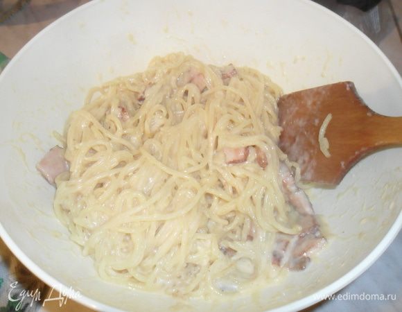 Затем частями вмешивать пасту с беконом в соус. Хорошо перемешивая. При  необходимости добавить воды где варилась паста.