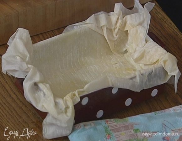 Смазать пласт теста фило сливочным маслом, свернуть его пополам, затем смазать маслом верхний слой и выложить тесто в форму смазанной частью вниз, так чтобы края свешивались из формы. 