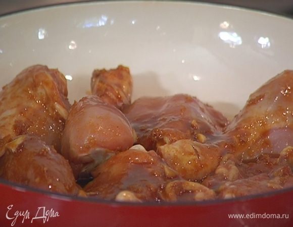 В тяжелой глубокой сковороде, которую можно ставить в духовку, разогреть оливковое масло, выложить курицу вместе с маринадом и обжарить со всех сторон до румяной корочки.