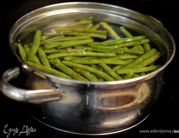 В небольшой емкости довести воду до кипения, посолить, положить фасоль. Готовить примерно 5 мин.