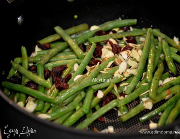 На горячую сквороду вылить оливковое масло, затем орехи и клюкву сушеную. Добавить фасоль, посолить и поперчить. Перемешать.