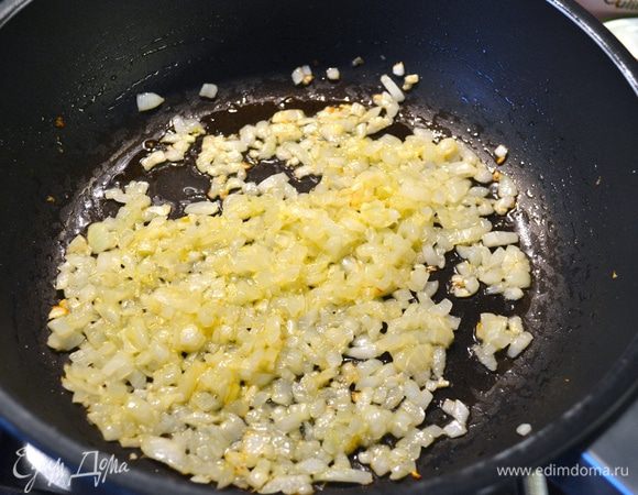 Подготовить овощи. Лук и чеснок мелко нарезать. Морковь и красный сладкий перец вымыть, очистить и нарезать мелкими кубиками. 
Разогреть в сковороде оливковое масло и положить обжариваться лук и чеснок. Обжаривать, помешивая 2-3 минуты пока лук не посветлеет.