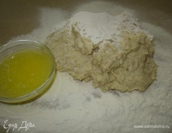 Для удобства лучше переложить тесто на присыпанную мукой рабочую поверхность и постепенно добавляя, растопленное и остуженное до комнатной температуры сливочное масло
