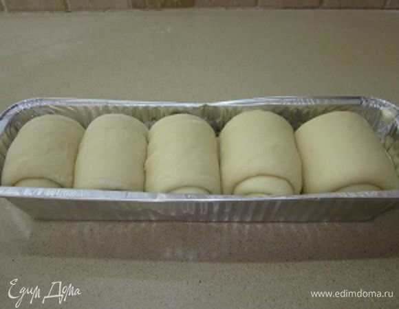 Готовые улитки выкладываю в смазанную растительным маслом форму, прикрываю чистой тряпочкой и убираю в шкафчик минут на 20-30 для окончательной расстойки.
