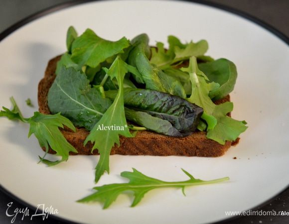 На хлеб свежий или разогретый в тостере выложить мягкое масло по желанию, затем свежие листья салата.
