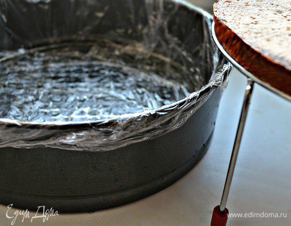 Собираем торт. Разъёмную форму выстелать пищевой плёнкой. На дно положить корж.