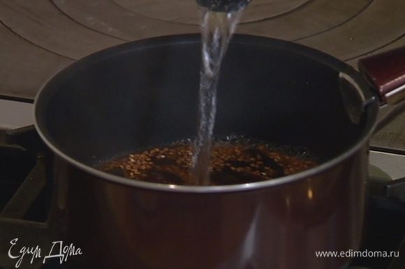 Измельченную курагу добавить к гречке, влить 2 стакана кипятка и варить под крышкой 5–6 минут до полуготовности.