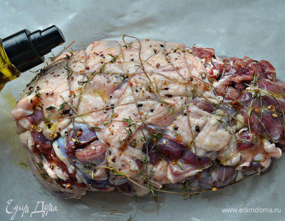 Сформированную ногу-рулет посолить и поперчить со всех сторон, смазать оливковым маслом и слегка промассировать мясо, чтобы все ароматы соединились.  Сверху уложить веточки тимьяна. Дополнительно я сбрызнула оливковым маслом с ароматом чёрного трюфеля, но это не обязательно. Уложить подготовленную ногу на бумагу для выпечки и поместить в разогретую до 180г духовку на 50 мин.