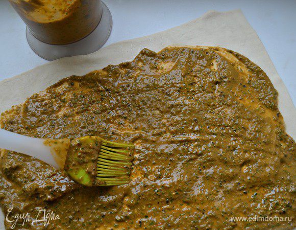 Слоёное тесто раскатать немного больше размера бараньей ноги.
Обильно смазать топенадой. 