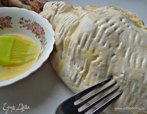 Затем укутать ногу тестом и уложить на противень, выстеленный пергаментом. С помощью вилки сделать наколы по всей поверхности.
Взбить яйцо и смазать им тесто. Теперь баранью ногу необходимо запечь второй раз. Ставим снова её в разогретую до 180г духовку на 45 мин.