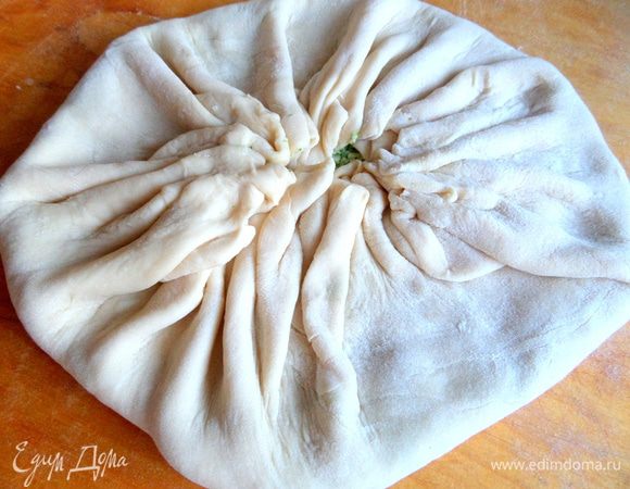 Соединяем края эластичного теста к центру и защипываем.