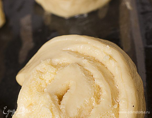 Кусочки выкладываем на смазанный маслом противень срезом вниз. Оставить на 1 час, прикрыв салфеткой. Булочки должны увеличиться в объёме.