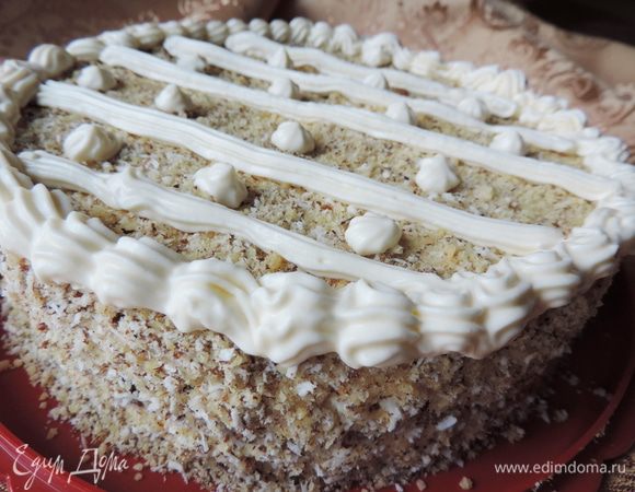 Утром освобождаем торт от бортиков формы. Я просто аккуратно провожу ножом вдоль бортика и снимаю кольцо. 
Верх и бока торта посыпаем молотыми грецкими орехами, смешанными с кокосовой стружкой. На этом можно остановиться. Но я с вечера оставила пару ложек крема и поиздевалась над верхом торта.