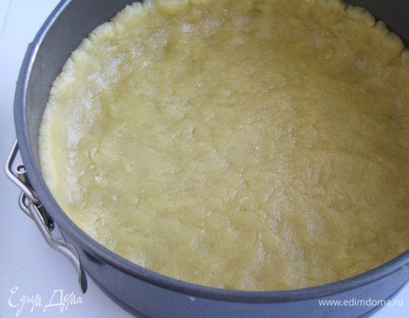 Руками равномерно распределить тесто по форме, сделать небольшие бортики.