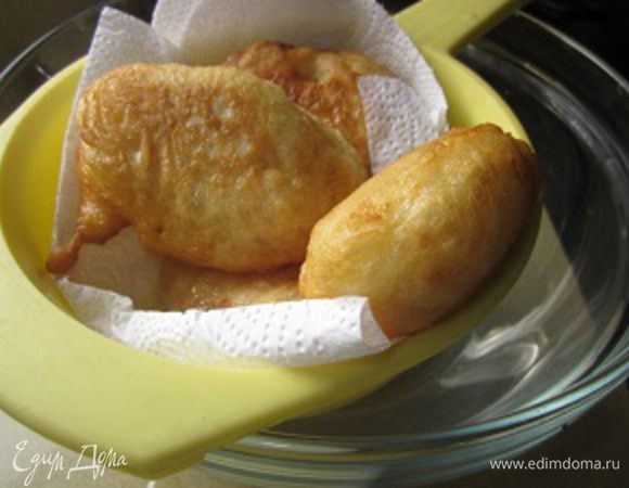 Готовые пончики выкладываем в ситечко, застеленное бумажным полотенцем. Все-таки маслица на них много, пусть хоть немного да промакнутся.