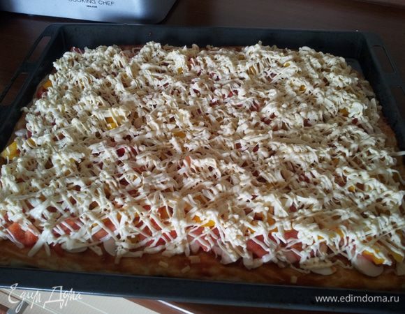 Затем в пачке майонеза отрезем уголок так, чтоб можно было полить тонкой струйкой. Плавленный сыр трем на крупную терку прямо над пиццей.