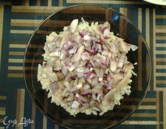 Итак, все подготовлено, можно начинать собирать салат. Возьмите крупную терку. Первым слоем на дно салатника натрите картофель. Затем выложите часть селедки, сверху — лук. Полейте небольшим количеством растительного масла.