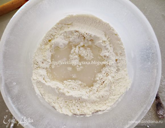 Сделав углубление в муке, добавляем воду, уксус, соль и начинаем замес теста.