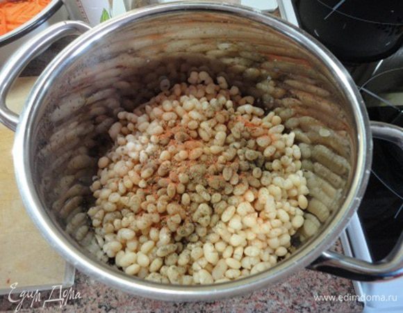На фасоль высыпать пряности и соль, но не перемешивать. Можно сюда же выдавить зубчик чеснока.