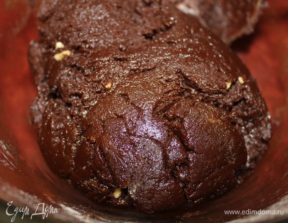 К шоколадной массе добавить сухие ингредиенты и тщательно всё замесить. Тесто получается упругим. Я вымешивала ложкой, можно и лопатку использовать. У меня в тесте видны мелкие частицы орехов, это у меня плитка шоколада была с орехами. Теперь тесто под плёнку и в холодильник на 2 часа. Важно выдержать указанное время, чтоб трещинки получились.