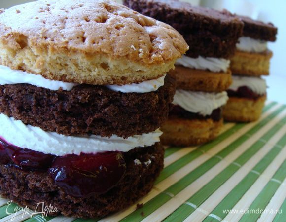 Обрезки измельчаем в крошку блендером.
 В оставшуюся сметану (250 г) добавляем немного сахара по вкусу и обмазываем ею пирожные сверху и с боков. Я делала это пальцами.
Затем сухими руками обваливаем пирожные в крошке. 
Сверху украшаем сливками и вишней.