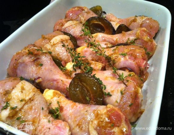 В огнеупорную форму выложите лук, сливы кожицей вниз, курицу,  2 веточки тимьяна...