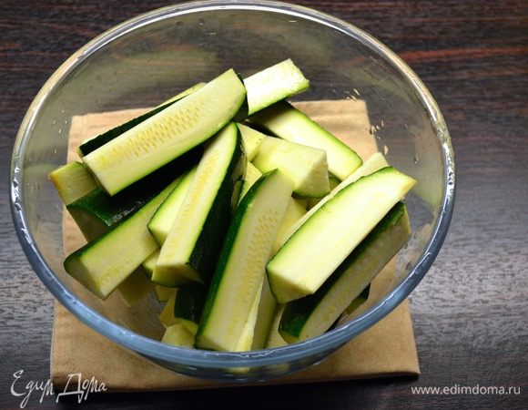 Цукини вымыть и нарезать брусочками. Духовку включить нагреваться на 180°C.