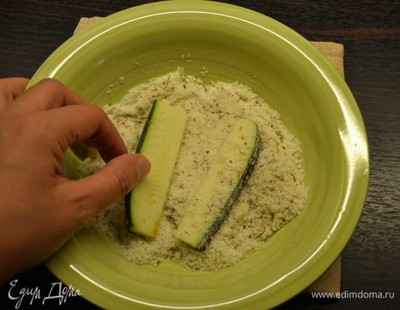 Противень застелить пекарской бумагой. Брусочки цукини обвалять в полученной смеси. По рецепту предлагается просто выложить цукини на противень и присыпать сверху, но, мне кажется, что таким образом они более равномерно покрываются ароматной смесью.