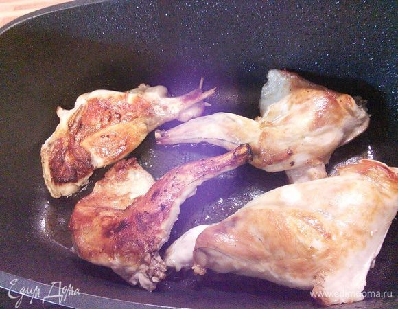 В жаропрочной кастрюле разогрейте масло, обжарьте части кролика со всех сторон до золотистого цвета. Затем выложите мясо на тарелку. 