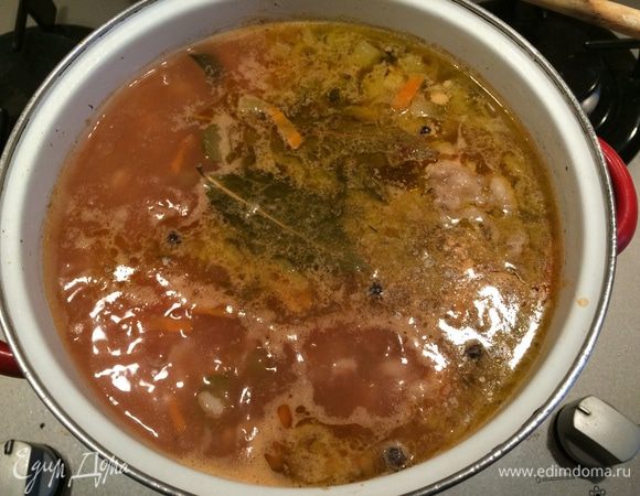 Когда бульон сварится, мясо вынуть, отобрать от кости и нарезать небольшими кусочками. Положить в кипящий бульон промытую перловую крупу, довести до кипения и варить 20 минут. Затем добавить очищенный и нарезанный кубиками картофель и готовить еще 20 минут. В сковороду с зажаркой влить несколько столовых ложек из бульона, перемешать и добавить все в рассольник вместе с кусочками мяса. Затем влить томатный сок. Готовить еще около пяти минут.