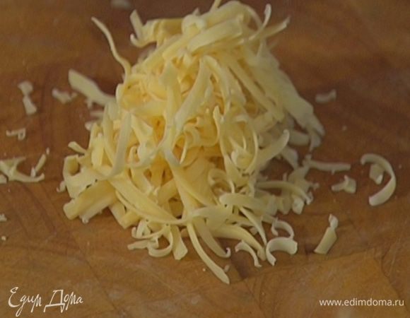 Сыр натереть на крупной терке, отправить к макаронам и перемешать.