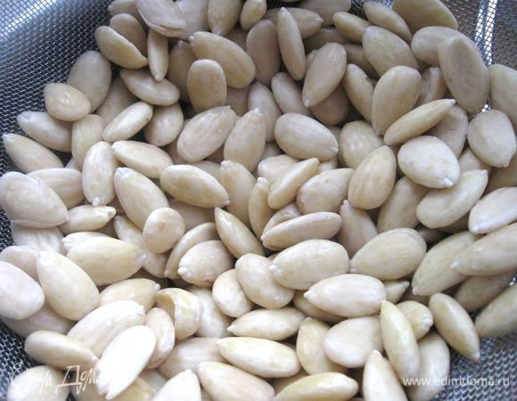 Миндаль поместить в кипяток на 4 -5 минут, слить воду, очистить от шелухи.  Подсушить на сковороде без добавления масла.