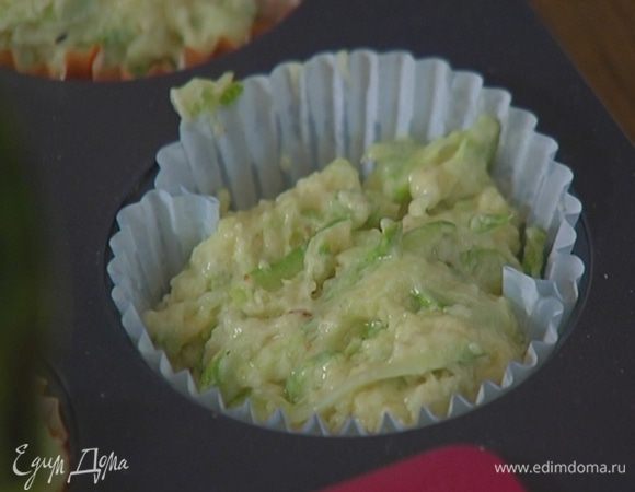 Формочки для маффинов выстелить бумажными вкладышами, смазать их оливковым маслом и разложить тесто.