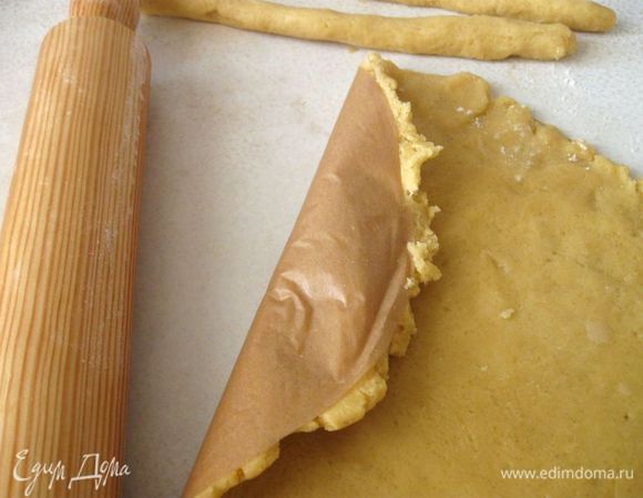 Тесто вынуть из холодильника, раскатать. Часть теста оставить для бортиков. Я раскатываю тесто на бумаге для выпечки, уже отрезанной по размеру формы.