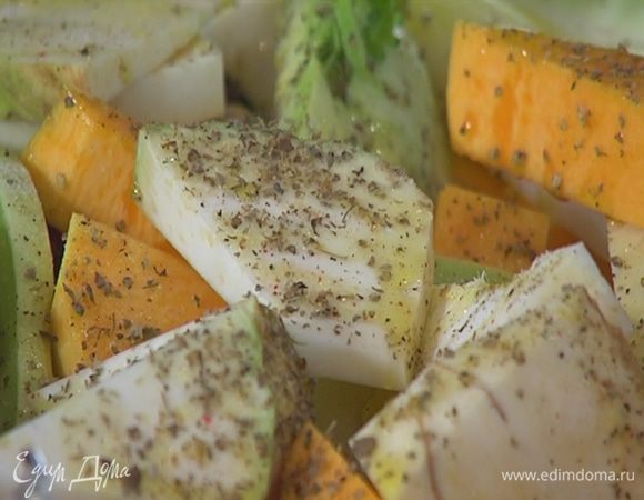 Небольшую форму для выпечки выстелить фольгой, так чтобы края свешивались, выложить нарезанные овощи, сбрызнуть оливковым маслом, немного посолить, поперчить, посыпать майораном.