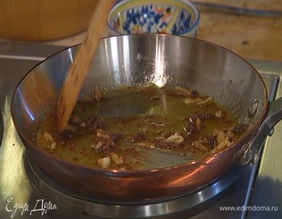 Разогреть в сковороде оливковое масло, выложить чеснок и анчоусы, все перемешать.