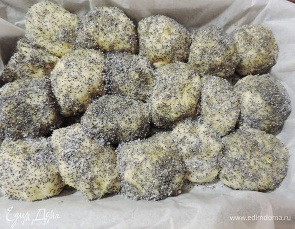 Подошедшее тесто немного обмять. Теперь отрываем от теста небольшие кусочки, расплющиваем в лепешку, в каждую заворачиваем половинку сливы. Затем при помощи ложки обваливаем полученный мини-пирожок сначала в растопленном масле, затем в сахарно-маковой смеси. Выкладываем пирожки плотно друг к дружке.  У меня противень 25*16см, выстеленный бумагой. Если после формовки масло останется - полейте им пирог сверху. Оставляем пирог на 20 минут на расстойку.