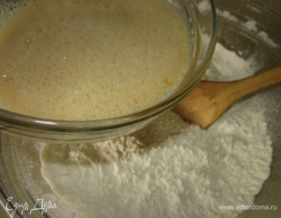 И добавляя в нее (муку) жидкости из яиц и дрожжей начинаем замешивать тесто.
