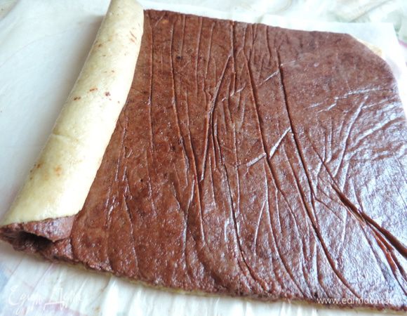 Теперь шоколадный пласт кладем сверху на белый. Прижимаем руками, чтоб он прилип. заворачиваем тесто в плотный рулет, помогая себе бумагой. Полученный рулет заворачиваем в бумагу и отправляем в морозилку примерно на час, может понадобиться времени немного больше (меньше) Нам надо, чтоб наш рулет хорошенько затвердел, но резался ножом без усилий.