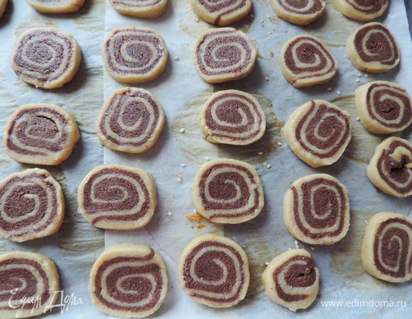 Затвердевший рулет нарезаем ножом на кусочки толщиной 3-4мм. Руками придаем круглую форму, ведь при нарезке рулет может слегка деформироваться и выкладываем на противень, застеленный бумагой.