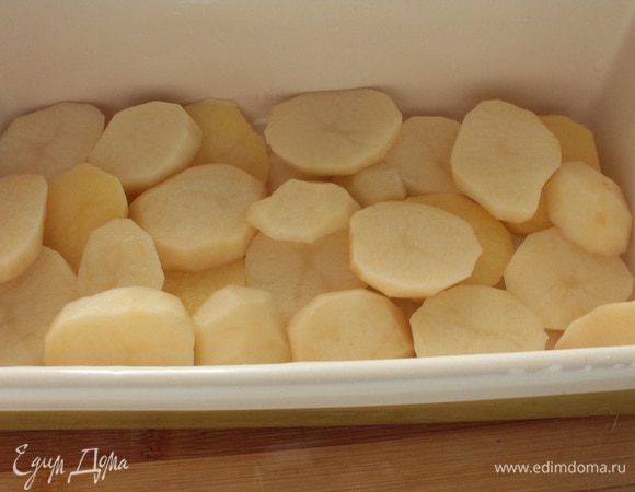 Картофель почистить,нарезать тонкими ломтиками.В форму для запекания (у меня керамическая) выкладываем половину картофеля .