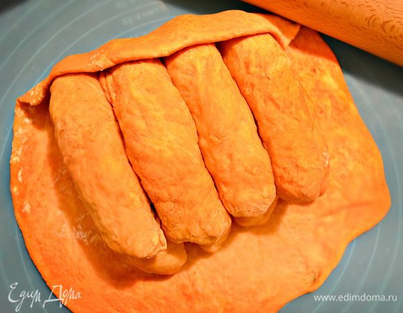 Раскатываем остаток томатного теста в пласт, складываем в него  подготовленные "куколки" теста и защипываем.