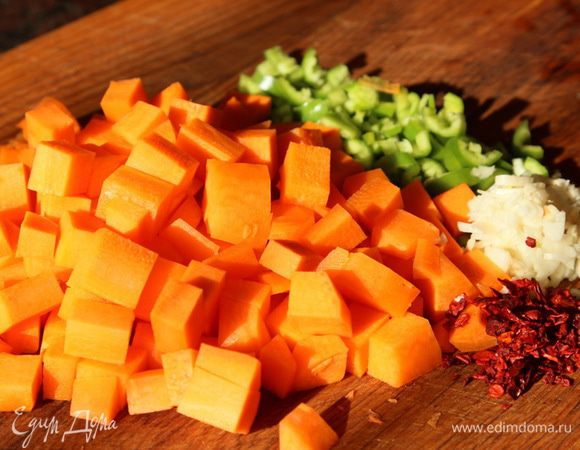 Морковь нарезаем кубиком, горький перец и чеснок рубим и отправляем к мясу. Добавляем лепестки перца чили или просто сушеный красный острый перец, тимьян. 