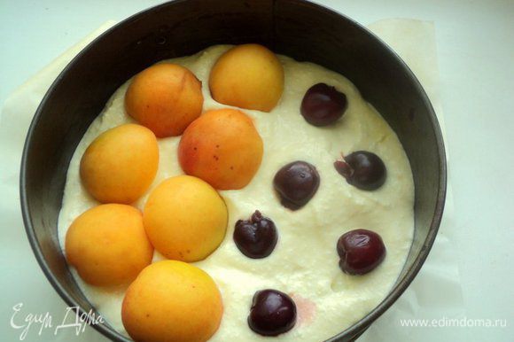 На выпеченную основу выложить немного творожной массы. Разложить вишенки, на них половинки абрикос.