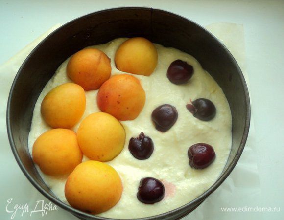 На выпеченную основу выложить немного творожной массы. Разложить вишенки, на них половинки абрикос.
