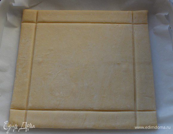 Тесто разморозить при комнатной температуре. Выложить на лист пергамента, тупой стороной ножа сделать глубокие бороздки, не прорезая до конца, с четырех сторон.