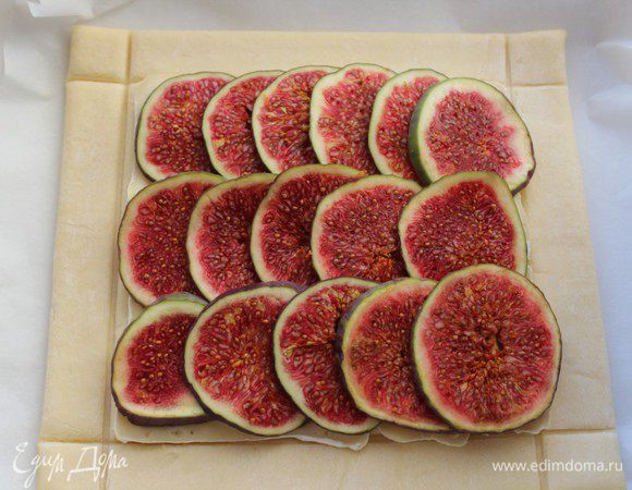 На сыр выложить колечки инжира. Смазать бортики сливками и запекать в предварительно разогретой до 200 градусов духовке 15-20 минут.