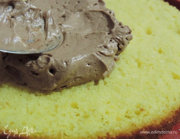 Теперь выкладываем на бисквит примерно треть крема.