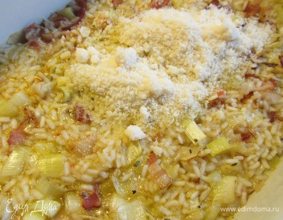 Вынимаем ризотто из духовку добавляем 2 ст.л. тертого пекорино романо (или пармезана), перемешиваем. Готовим ризотто еще 15 минут.
