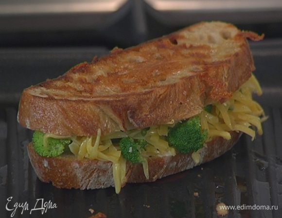 Разогреть в сковороде-гриль оливковое масло и, прижимая бутерброд к сковороде, обжаривать его с двух сторон до появления золотистых полосочек.